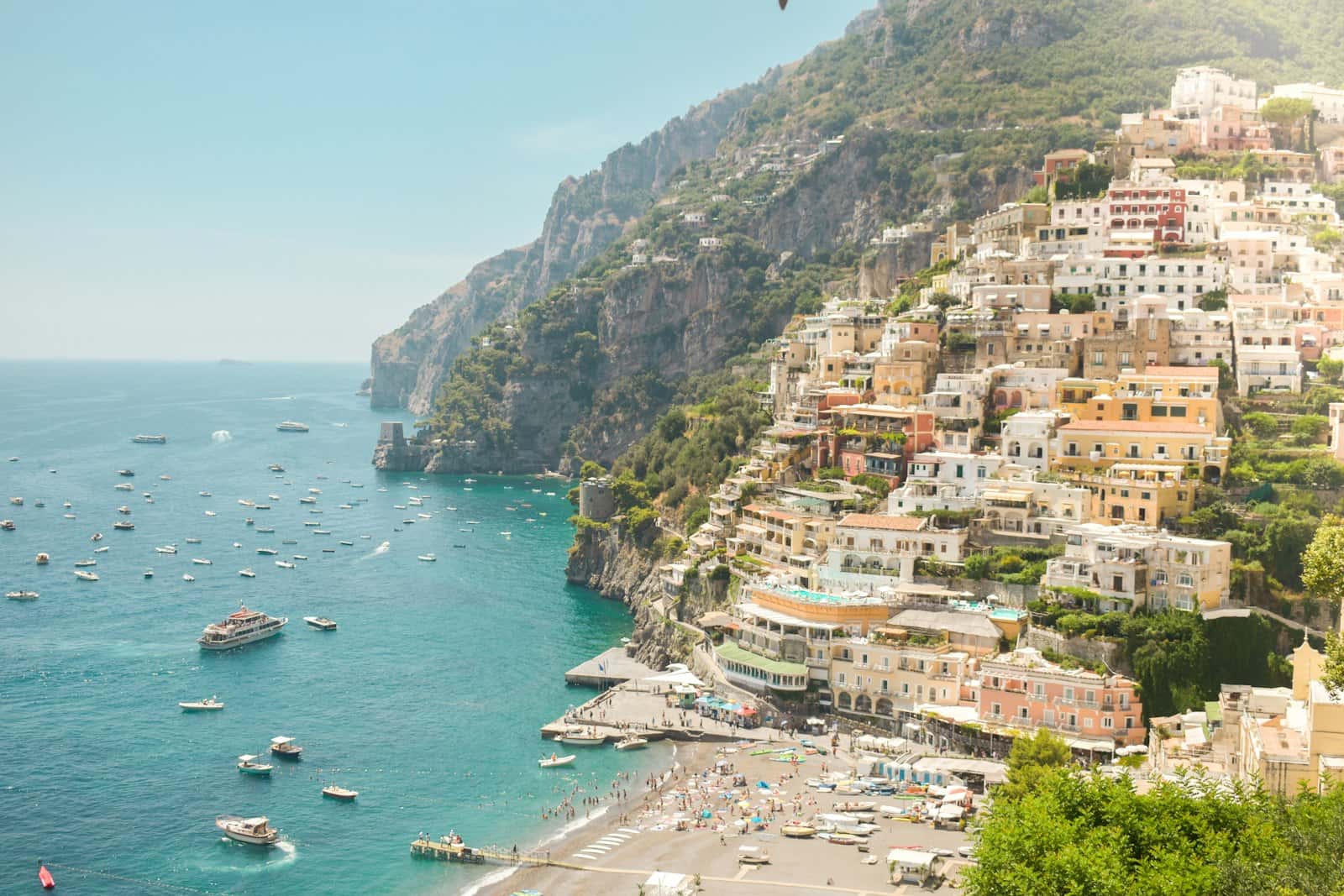 Pastel houses stacked up the cliffs of Positano above the turquoise sea on the Amalfi Coast